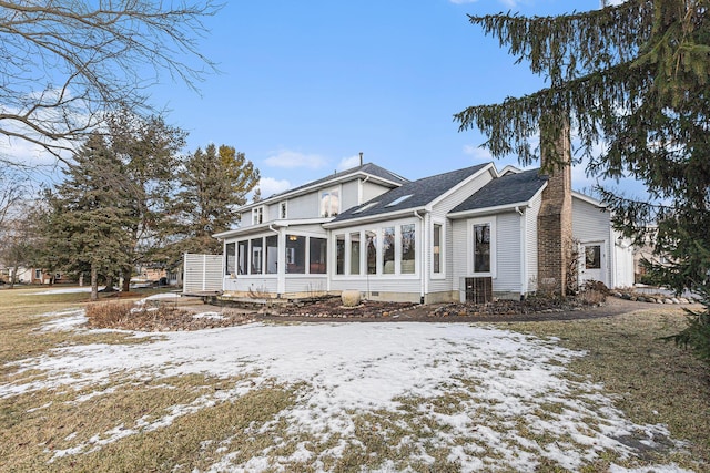 view of front of property with roof with shingles, a sunroom, and central air condition unit