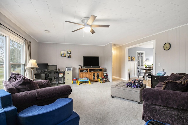 living room with carpet floors, visible vents, crown molding, and ceiling fan