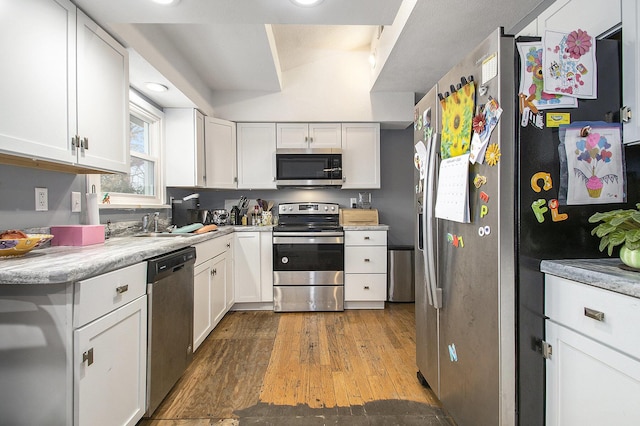 kitchen with light countertops, appliances with stainless steel finishes, white cabinetry, and light wood-style floors