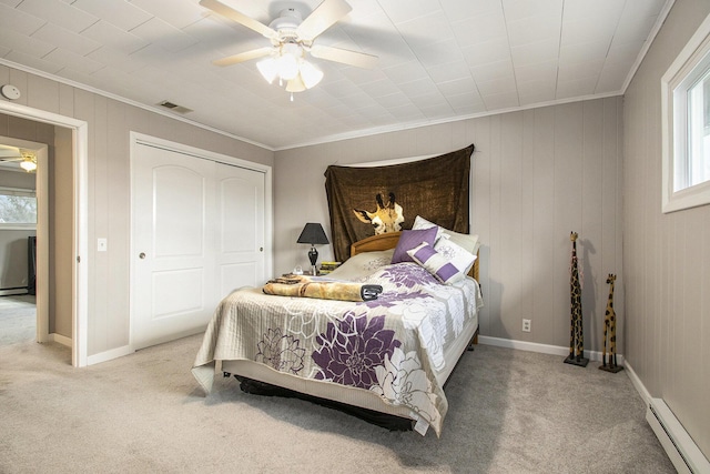 bedroom featuring carpet floors, visible vents, multiple windows, and a baseboard heating unit