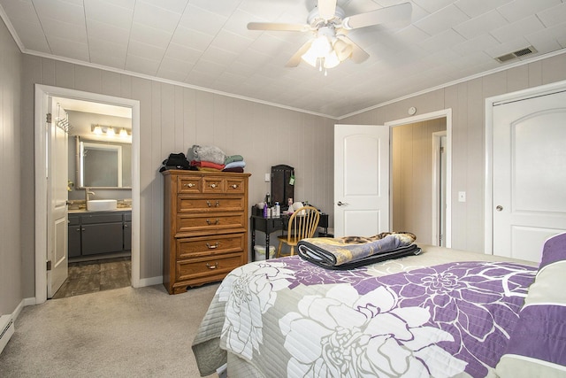 bedroom featuring a baseboard heating unit, carpet floors, visible vents, ensuite bath, and crown molding