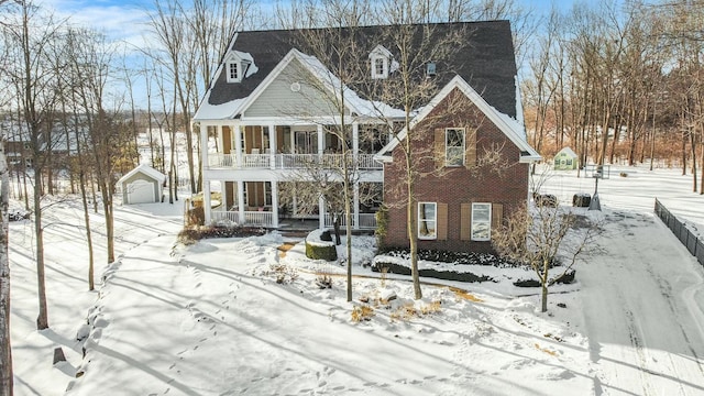 view of front facade with a balcony, a porch, and brick siding