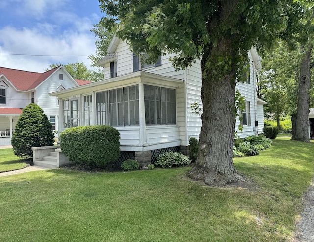 view of front of house with a sunroom and a front lawn