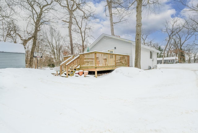 snow covered rear of property with a wooden deck