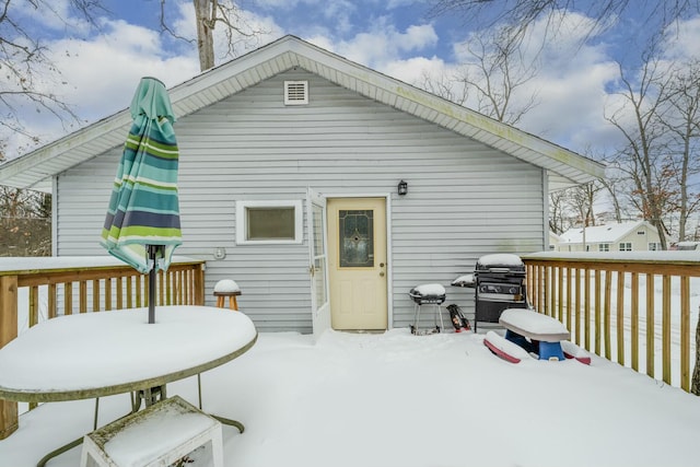 snow covered house featuring a wooden deck