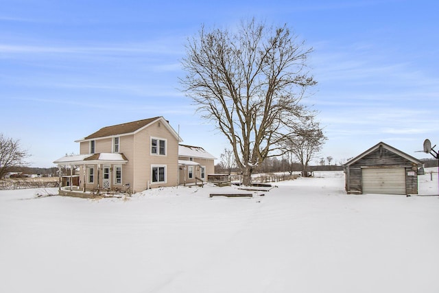 snowy yard with a detached garage and an outdoor structure