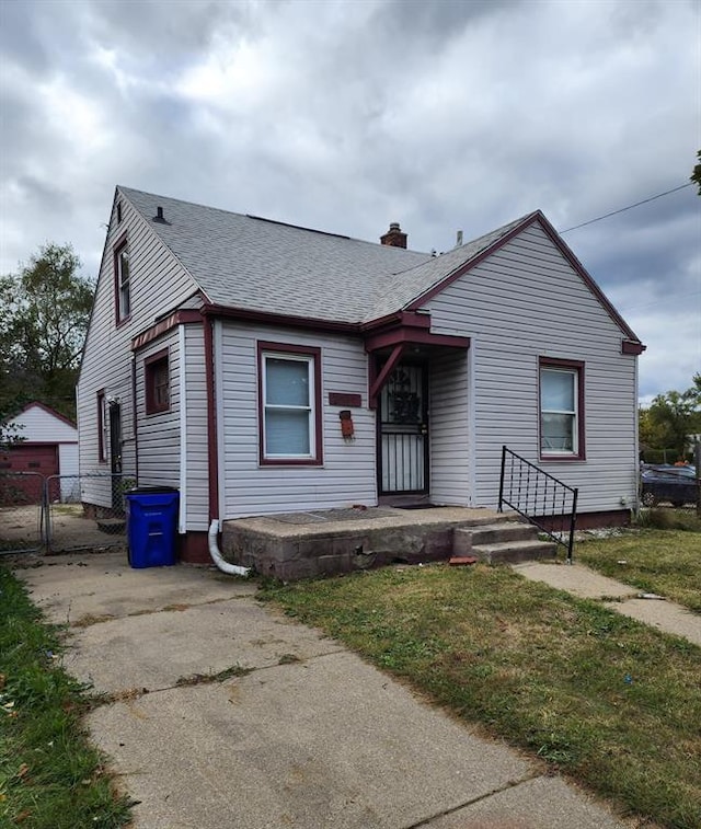 bungalow-style house with a garage and an outbuilding