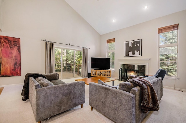 living room with high vaulted ceiling, a wealth of natural light, baseboards, and a premium fireplace