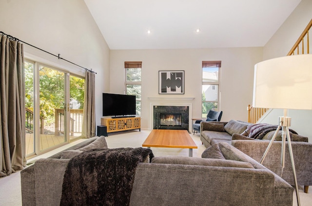 carpeted living room with high vaulted ceiling, a premium fireplace, stairway, and recessed lighting