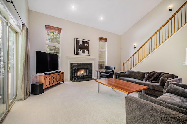 living room featuring a high end fireplace, stairway, carpet, and recessed lighting