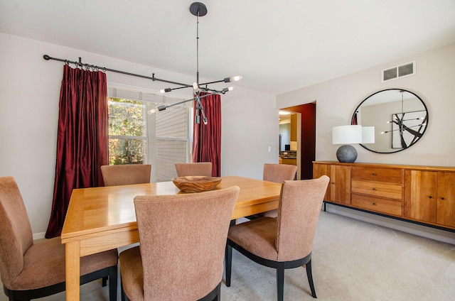 dining area with a notable chandelier, baseboard heating, visible vents, and light colored carpet