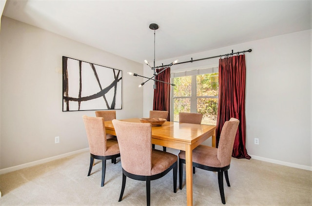 dining room with light carpet, baseboards, and a chandelier