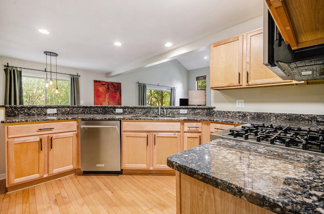 kitchen with plenty of natural light, vaulted ceiling, a sink, and light wood-style flooring