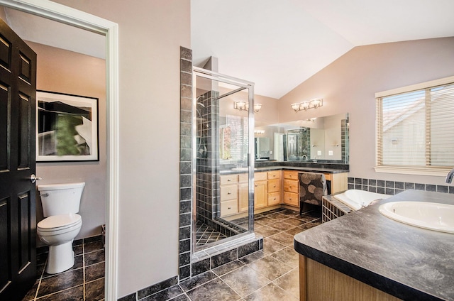 full bathroom featuring toilet, a sink, two vanities, vaulted ceiling, and a stall shower