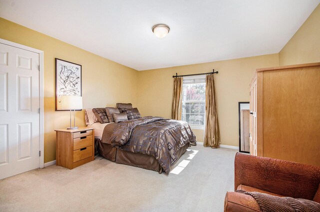 bedroom with light carpet and baseboards