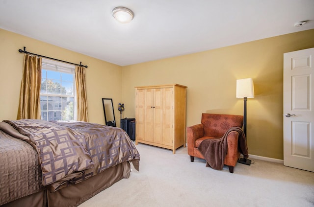 bedroom featuring baseboards and light colored carpet