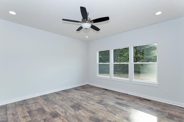 empty room with a textured ceiling, dark wood-type flooring, and ceiling fan