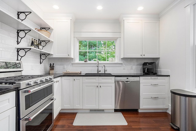 kitchen featuring appliances with stainless steel finishes, sink, white cabinetry, dark hardwood / wood-style flooring, and ornamental molding