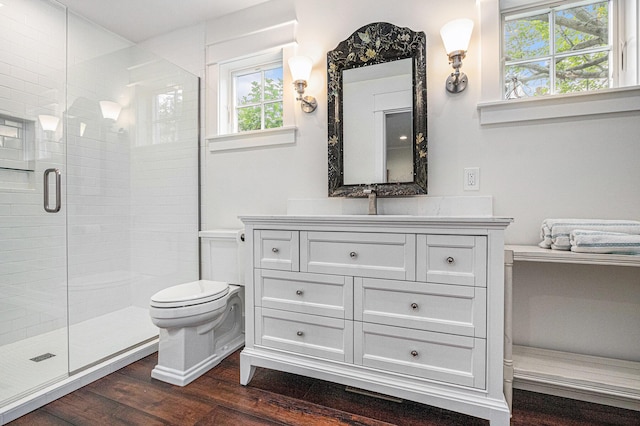 bathroom with hardwood / wood-style flooring, vanity, an enclosed shower, and toilet