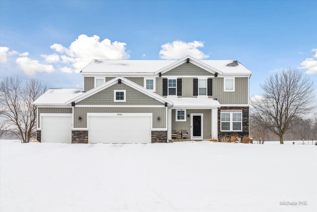 view of front of house featuring a garage, stone siding, and board and batten siding