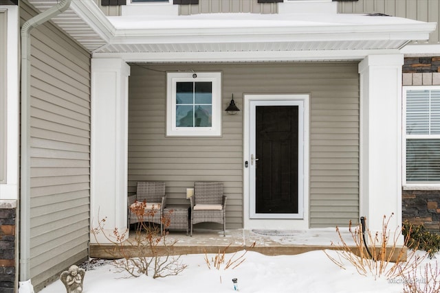 snow covered property entrance featuring board and batten siding