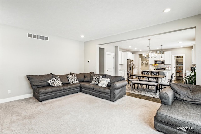 carpeted living room featuring a chandelier, recessed lighting, visible vents, and baseboards