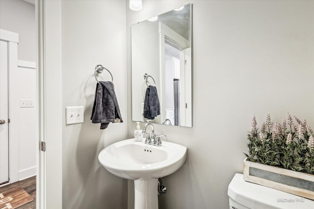 bathroom with toilet and wood finished floors