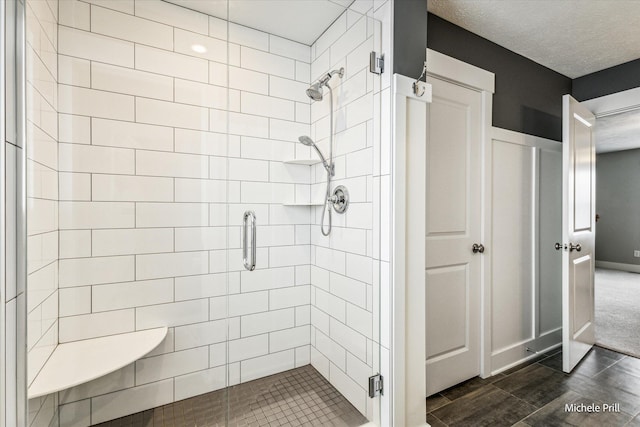 bathroom with a shower stall, a textured ceiling, and wood finished floors