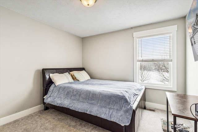 bedroom with visible vents, baseboards, a textured ceiling, and light colored carpet