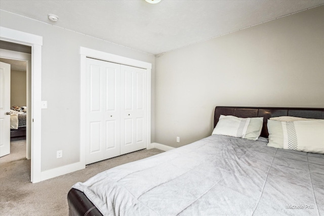 carpeted bedroom with a closet and baseboards