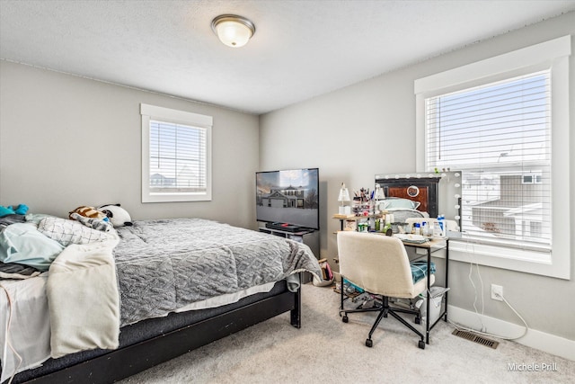 bedroom with baseboards, visible vents, a textured ceiling, and light colored carpet