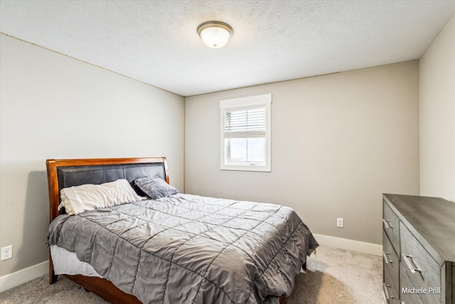 bedroom with light carpet, a textured ceiling, and baseboards