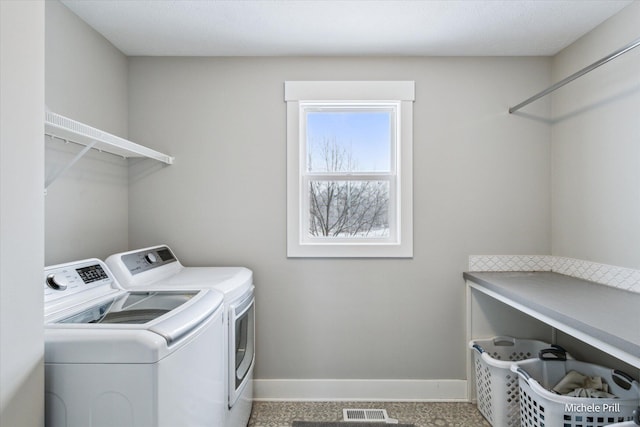 washroom with laundry area, visible vents, baseboards, and washing machine and clothes dryer