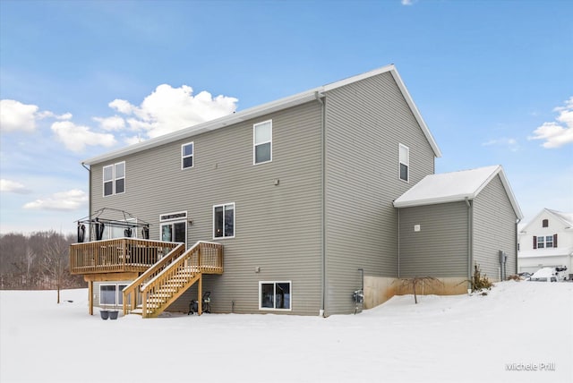 snow covered property with a deck, a gazebo, and stairs