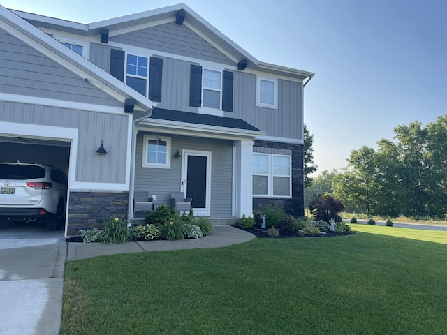 craftsman-style house with a garage, stone siding, a front lawn, and board and batten siding