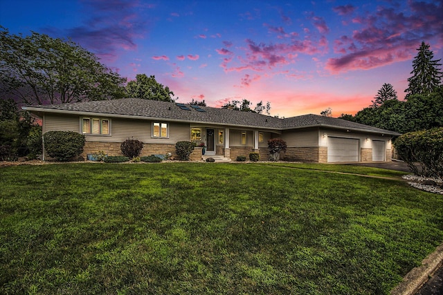 ranch-style home featuring stone siding, an attached garage, and a front lawn