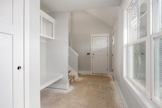 mudroom featuring lofted ceiling, light colored carpet, plenty of natural light, and baseboards