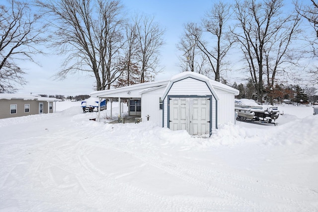 snow covered structure featuring a storage unit