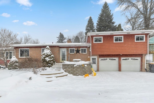 view of front of property featuring brick siding, a chimney, and an attached garage