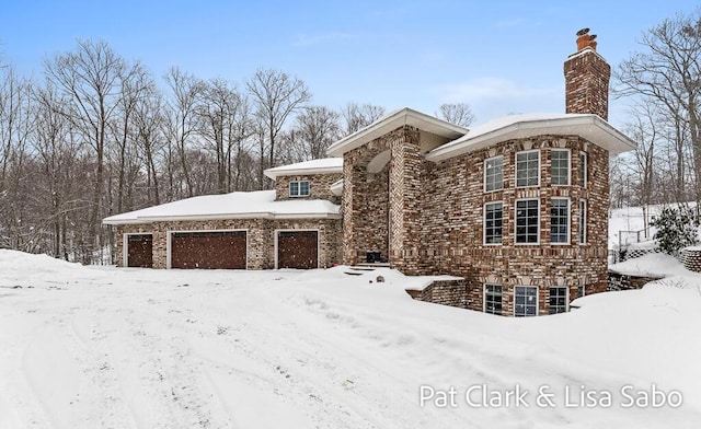 view of front of home with a chimney and an attached garage