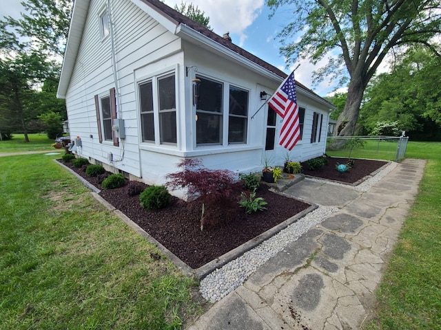 view of side of property featuring fence and a yard