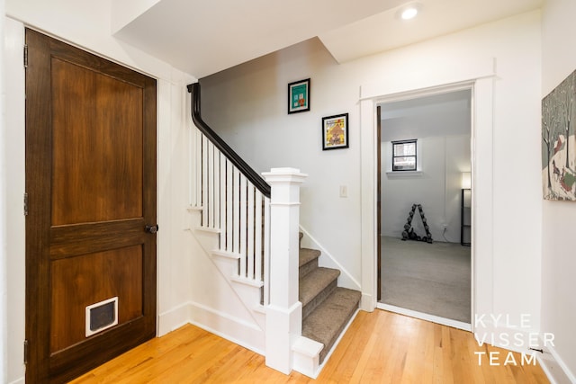 staircase featuring recessed lighting, visible vents, baseboards, and wood finished floors