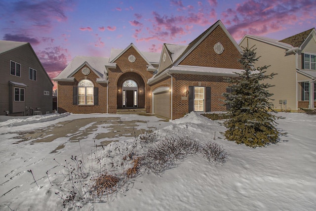 view of front of home with a garage and brick siding