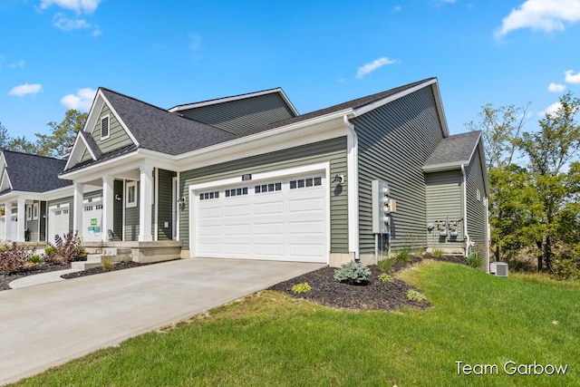 view of side of property featuring a lawn, a shingled roof, concrete driveway, and a garage