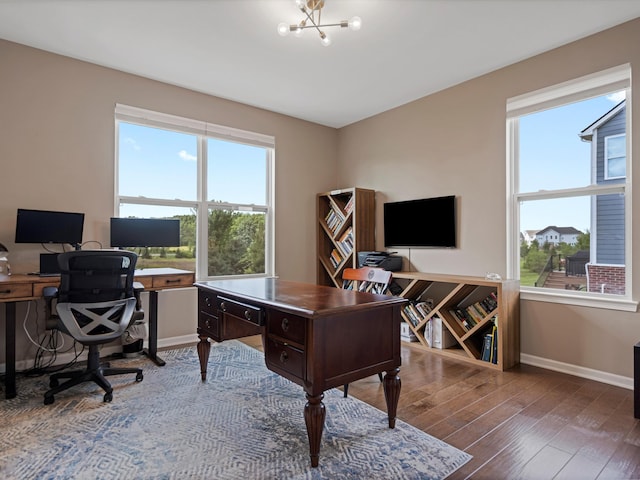 office area featuring dark wood finished floors, baseboards, and an inviting chandelier