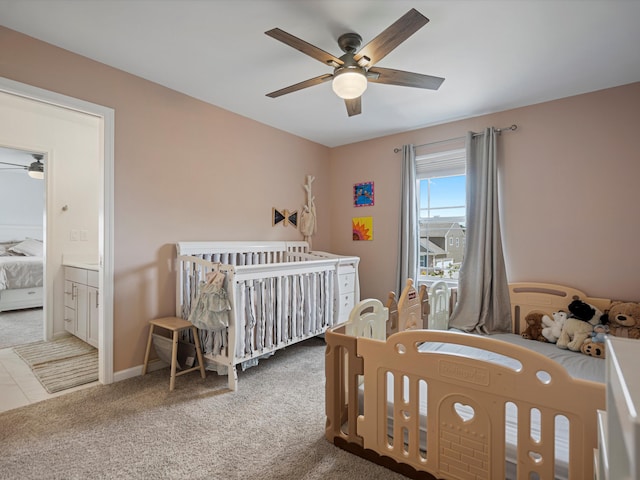 bedroom featuring ceiling fan, carpet floors, a crib, and baseboards