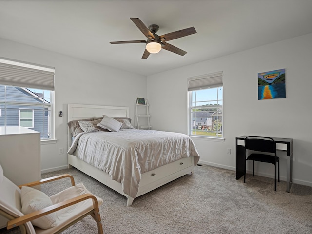 bedroom featuring a ceiling fan, light carpet, and baseboards