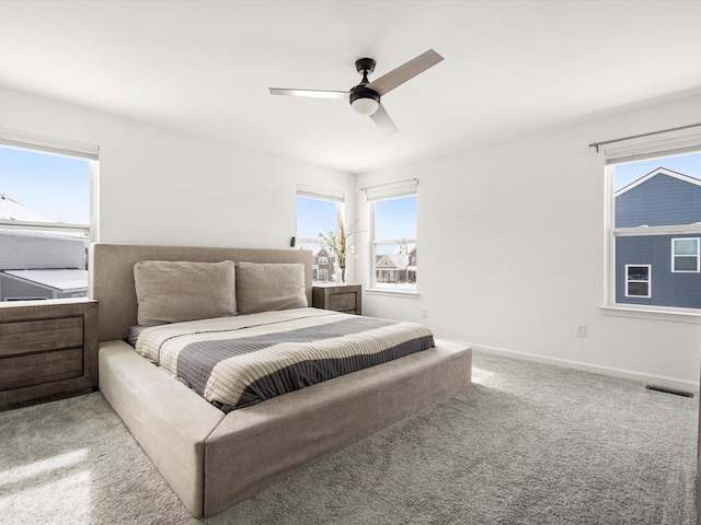 bedroom featuring baseboards, visible vents, ceiling fan, and light colored carpet