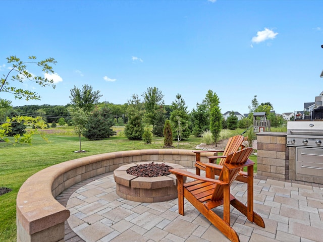 view of patio / terrace featuring a fire pit, an outdoor kitchen, and area for grilling