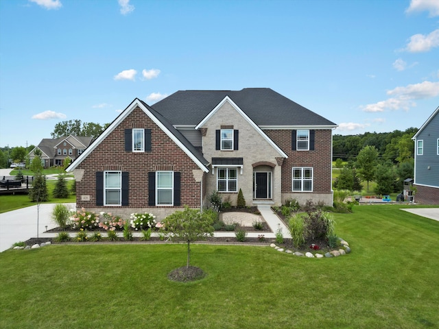 traditional home with a shingled roof, brick siding, and a front lawn